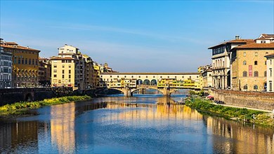 The Ponte Vecchio reflected in the water of the river Arno, Florence