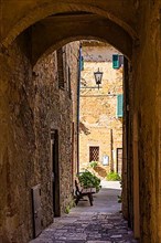 Archway and old stone houses in Monticchiello, Tuscany