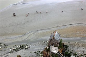 View from the monastery hill of Mont Saint-Michel towards the walkers on the mudflats and the Chapelle Saint-Aubert du Mont-Saint-Michel, Basse-Normandie