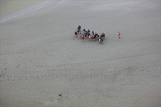 View from the monastery mountain Mont Saint-Michel to the walkers in the Wadden Sea, Basse-Normandie