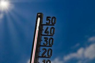 Symbolic image of the heat wave, thermometer at 45 degrees and sun rays