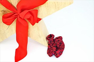 Christmas wooden star with a red bow isolated against a white background, Self-knitted socks on the side