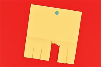 Empty yellow tear-off stub paper note without text on red background,