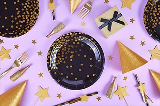 Party flat lay with black and golden plates, forks