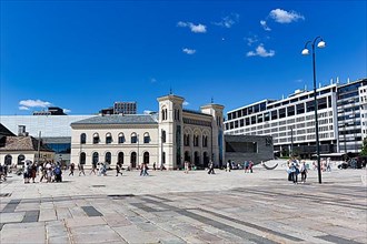 Pedestrians on City Hall Square with Nobel Peace Centre, former West Station