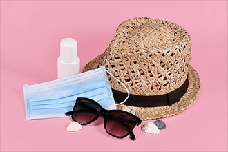 Concept for Summer vacation during Coronavirus crisis with face mask, straw hat