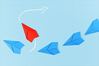 Red paper airplane flying out of line of blue airplanes. Concept for new business strategies, leadership