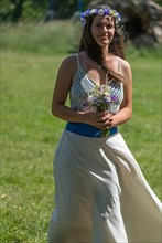 Bride striding across a meadow to the wedding ceremony, Mecklenburg-Western Pomerania