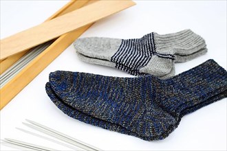 Self-knitted socks made of wool isolated against a white background. In different colours and sizes,