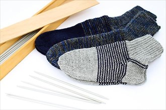 Self-knitted socks made of wool isolated against a white background. In different colours and sizes,