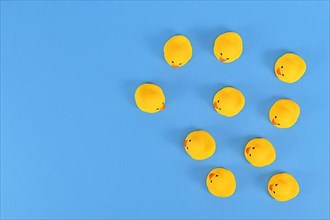 Top view of many yellow rubber ducks on blue background with copy space,