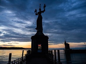 Statue of Imperia at the harbour entrance of Constance in the morning light in front of sunrise, Old Town