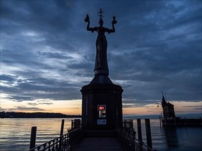 Statue of Imperia at the harbour entrance of Constance in the morning light in front of sunrise, Old Town