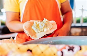 Hands of a vendor showing traditional raw pupusa. Elaboration of traditional pupusas, elaboration of the dough for traditional Nicaraguan pupusas