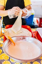 Preparation of Nicaraguan QUESILLO, traditional Central American food quesillo. Hands making a Nicaraguan quesillo. Close up of hands making a traditional quesillo with pickled onion