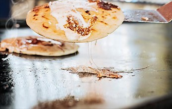 Traditional Nicaraguan Pupusas with melted cheese on grill. Traditional grilled cheese pupusas, Close up of traditional handmade pupusas on grill