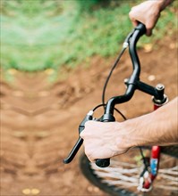 High angle of hands on bicycle handlebars, Side view of hands on bicycle handlebars. Concept of cyclist's hands on the handlebars
