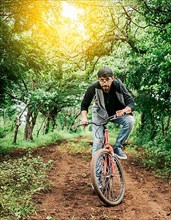 A guy riding a bike in the countryside, Person riding a bike in the countryside