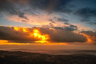 A Dramatic Sunset in the Evening with Clouds over a Valley in the Forest, Landscape Shot