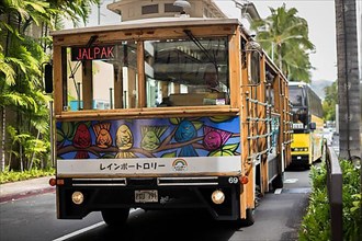 Waikiki Trolley in the streets of Oahu. The front of it shows Heather Browns art, Ohahu