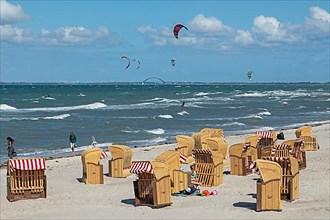Beach chairs, kite surfers