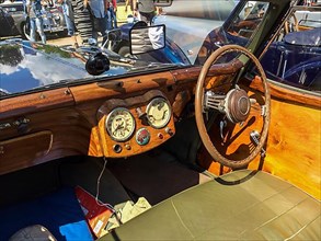View on wooden dashboard with classic analogue round instruments of historic sports car convertible Triumph Roadster 2000 from 40s 1949, Classic Days