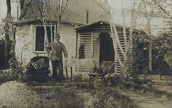 Man with hat in the garden in front of his house, ca 1900