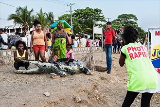 Photographer, photographs family with artificial crocodile