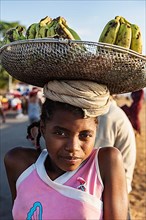 Girl with head load, basket with bananas