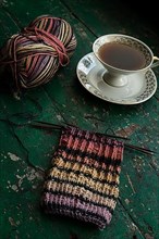 Handmade, Knitted piece with knitting needles and coffee