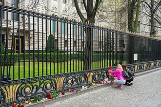 Women lay flowers at the fence of the Russian Embassy, Unter den Linden