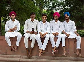 Young men in white suits and barefoot in Jallianwalla Bagh Park, Delhi