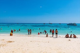 Tourists on a white sand beach and turquoise water, Koh Rok