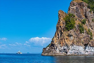 Boat before the rocky cliffs of the Koh Rok, Mu Ko Lanta National Park