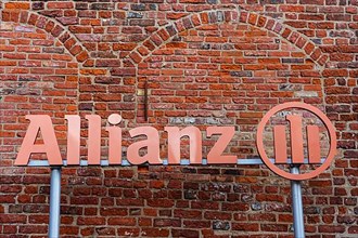 Allianz logo in front of red brick wall, Stralsund