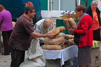 Selling bread at the market in Souillac in the Lot department in the far north-west of the Occitanie region in southern France,