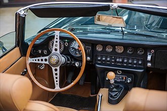 View into interior of left hand drive English historic classic sports car classic car roadster Jaguar E E-Type with steering wheel and dashboard, Techno Classica fair