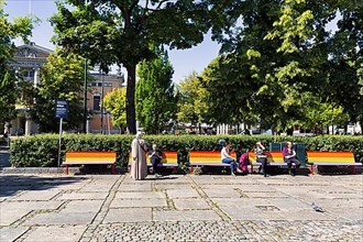 Street scene, men and woman on benches in rainbow colours