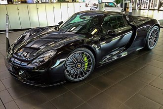Supercar sports car Porsche 918 hybrid, plug-in hybrid with two electric motors and mid-engine in Porsche showroom