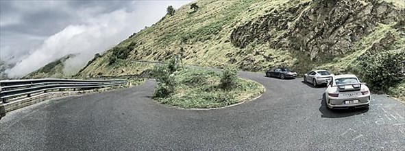 Three Porsche sports cars in front 911 GT3 behind Cayman 718 in the background 911 997 driving through a bend at Passo della Teglia, Ligurian Alps