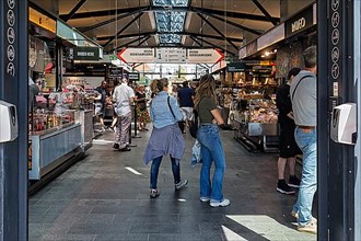 Visitors in the Torvehallerne market hall with street food and specialities, interior shot