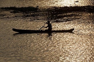 Man in canoe on sunrise. Kerala backwaters