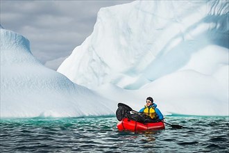 Man with packraft on fjord