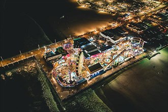 Circa November 2019: Santa Monica Pier at Night in super colourful lights from Aerial Drone perspective in Los Angeles