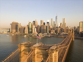 Brookyln Bridge Aerial view with American Flag waving and Manhattan Skyline in the background in Daylight HQ