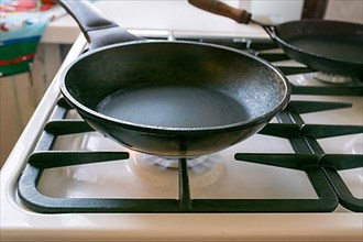 Black cast-iron pan is on a gas stove