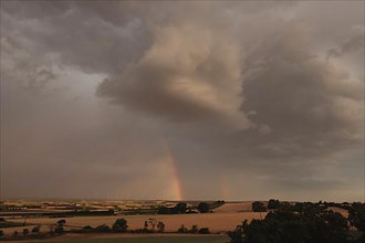 Storm and thunderstorm with a rainbow in the Hassberge district in Lower Franconia