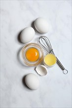 Egg yolk in small bowl and egg white in egg shell