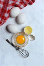 Egg yolk in small bowl and egg white in egg shell