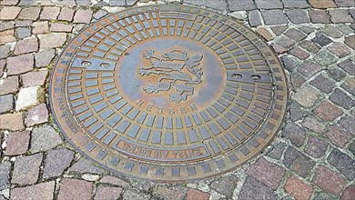 Manhole cover with the coat of arms of Seligenstadt. Seligenstadt